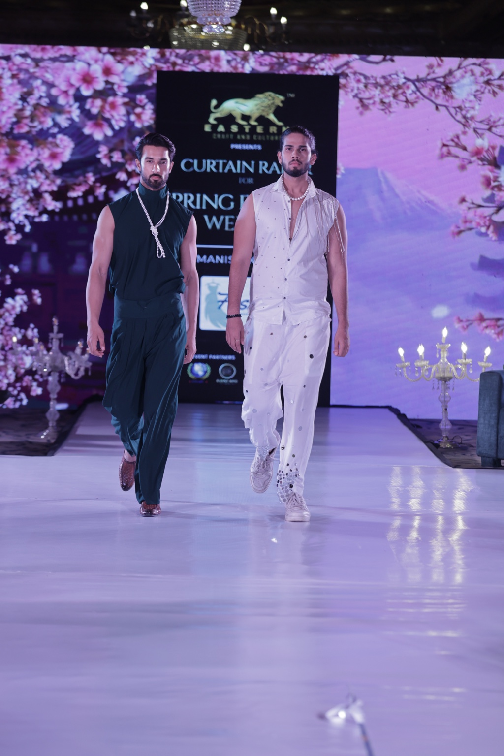 Two male models walking in contrasting runway looks